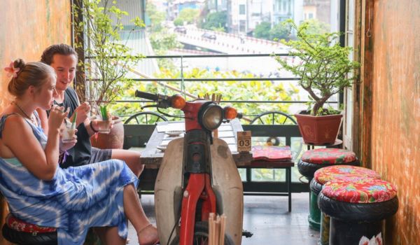 Les motos et leurs pneus usagés sont transformés en tables et chaises pour servir les clients dans un café de la rue Hang Mam, à Hanoï.