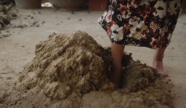 Les femmes Cham utiliseront leurs pieds pour donner des coups de pied afin que l'argile et le sable se mélangent (Photo : British Council)